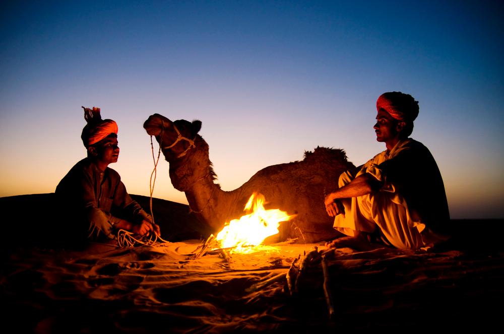 indian-men-resting-by-bonfire-with-their-camel-2